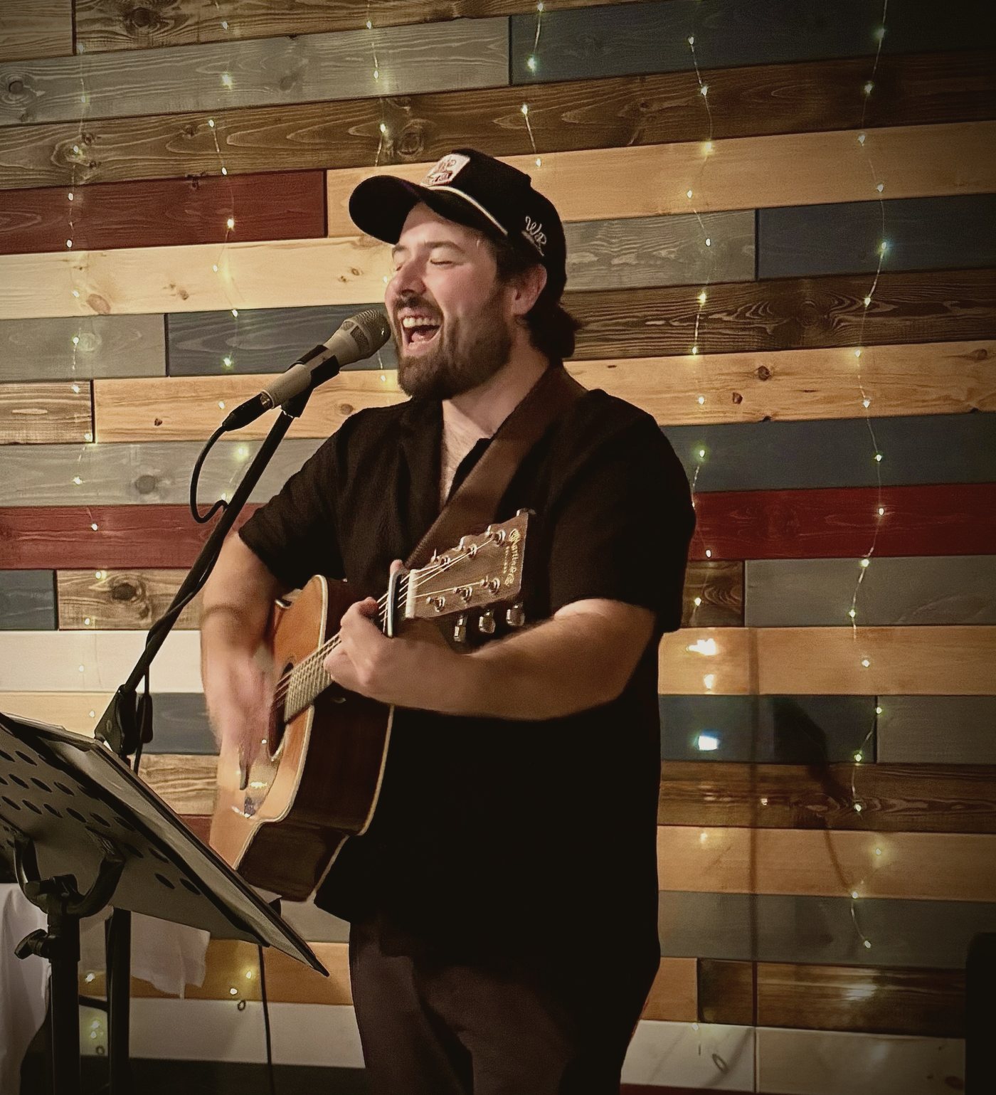 Matt Playne singing and playing acoustic guitar