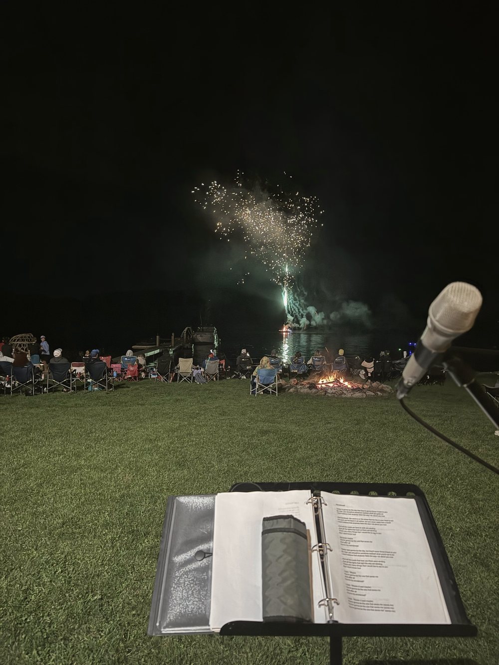 Fireworks over the lake seen from the performer's microphone